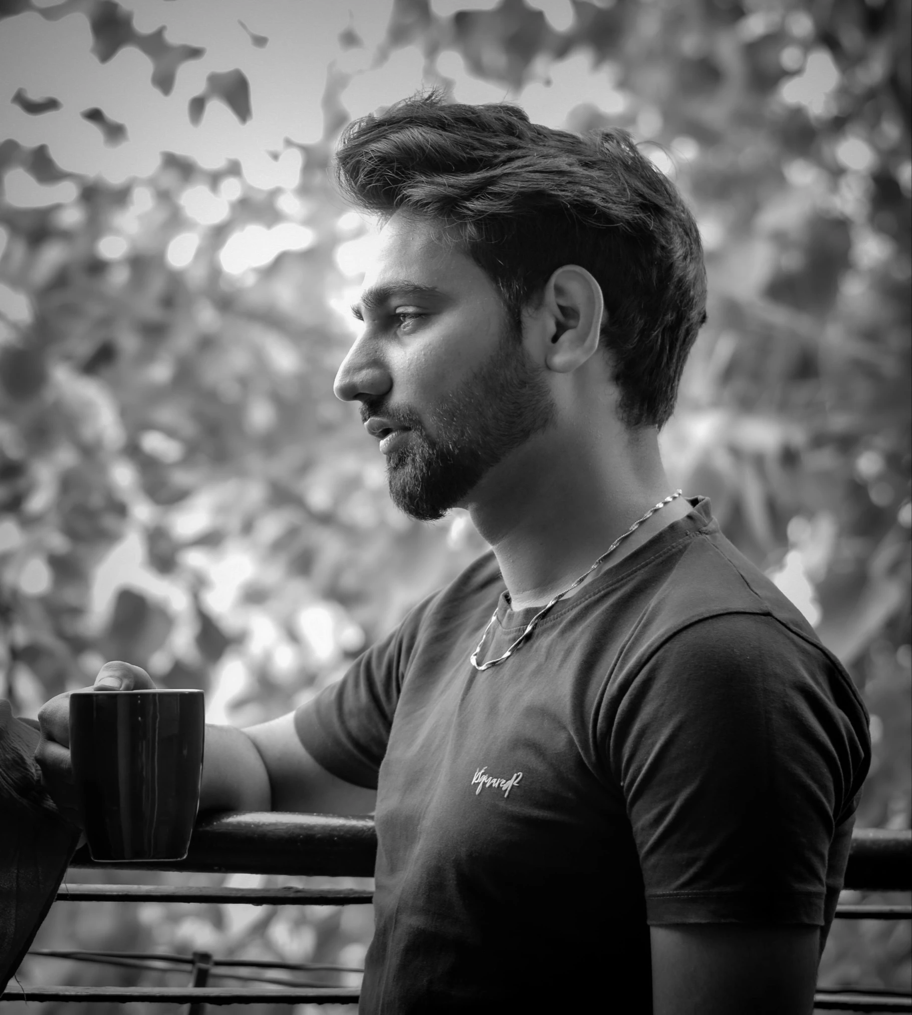 a young man in a black shirt drinking coffee