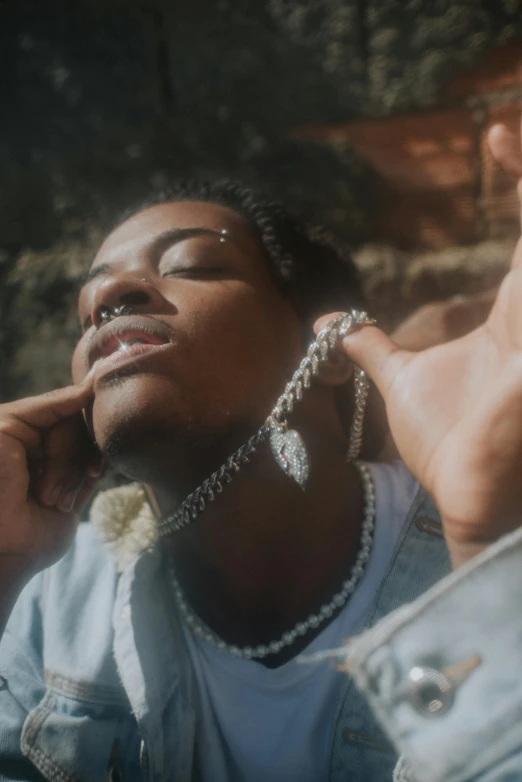 young black woman resting against a brick wall while wearing earrings