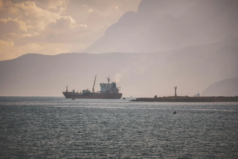 a barge traveling in the ocean under a cloudy sky