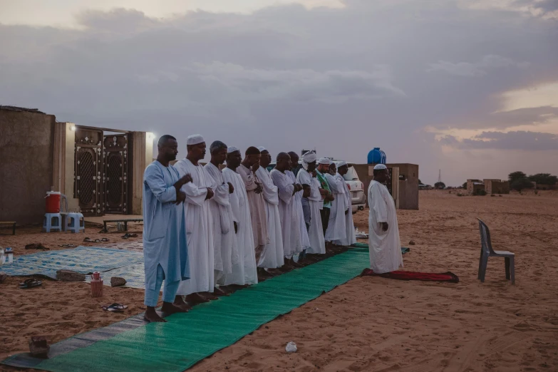 a group of men stand in a row as one person holds a sword