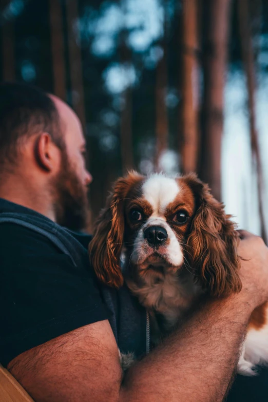 a man holding his dog in front of him