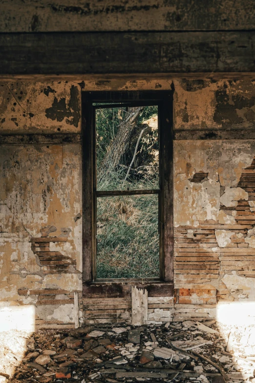 an open window sitting in a crumbling, abandoned building