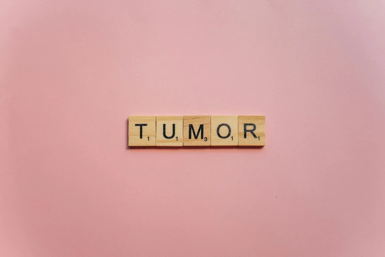 the word tumq written in wooden block type on pink background