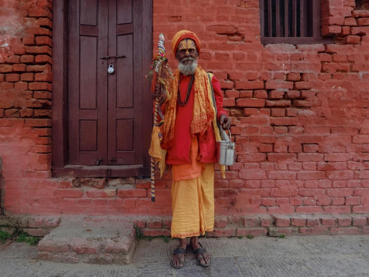 a man in red and yellow clothing is standing outside