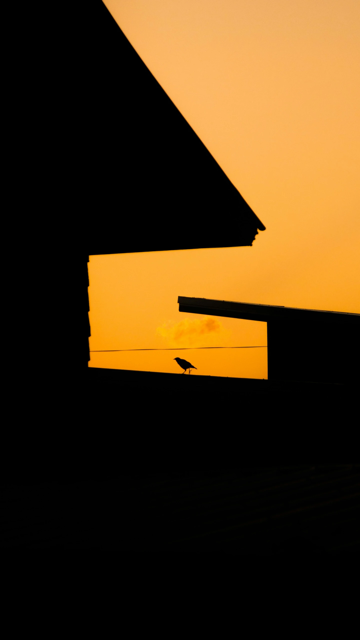 the setting sun in front of a barn