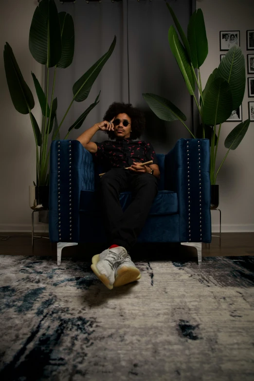 a man sitting in a chair in front of plants