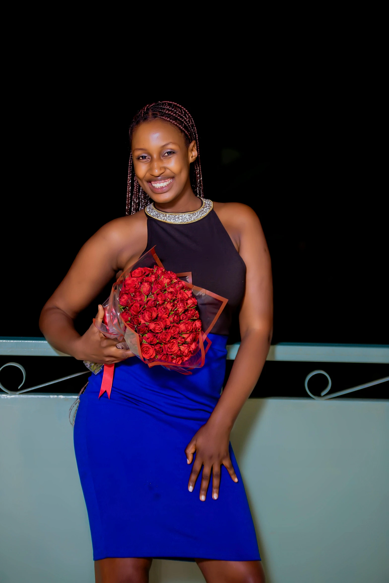 a woman posing with a bouquet of flowers in her hand