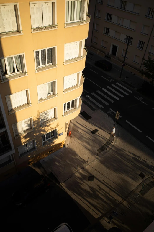 a person walking towards a yellow apartment building