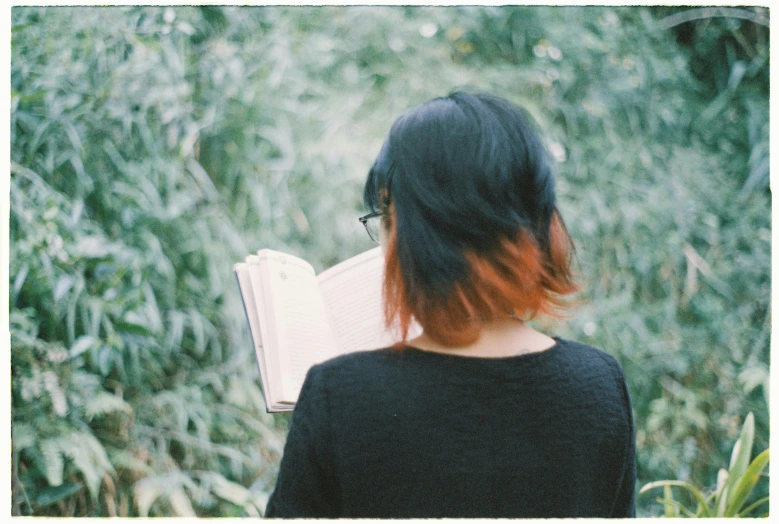 a woman is outside with an open book