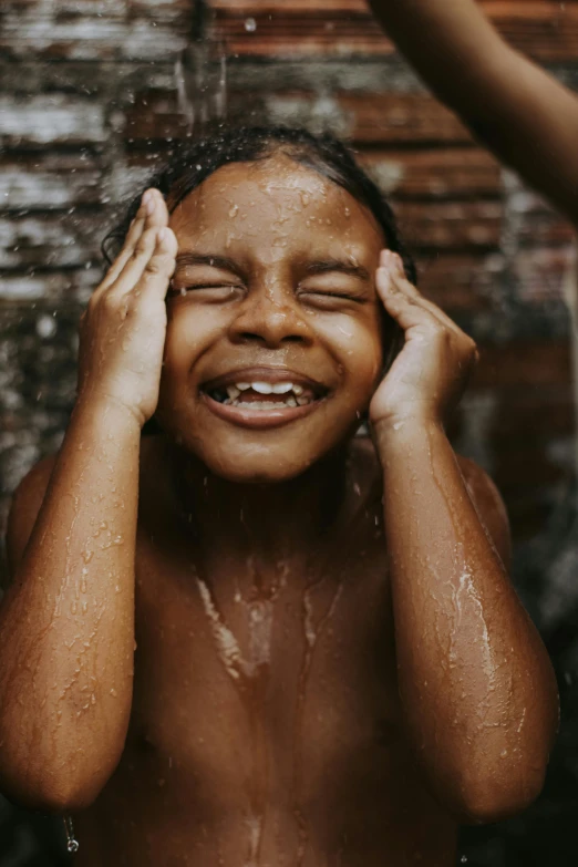 a girl is wet and laughing in the shower