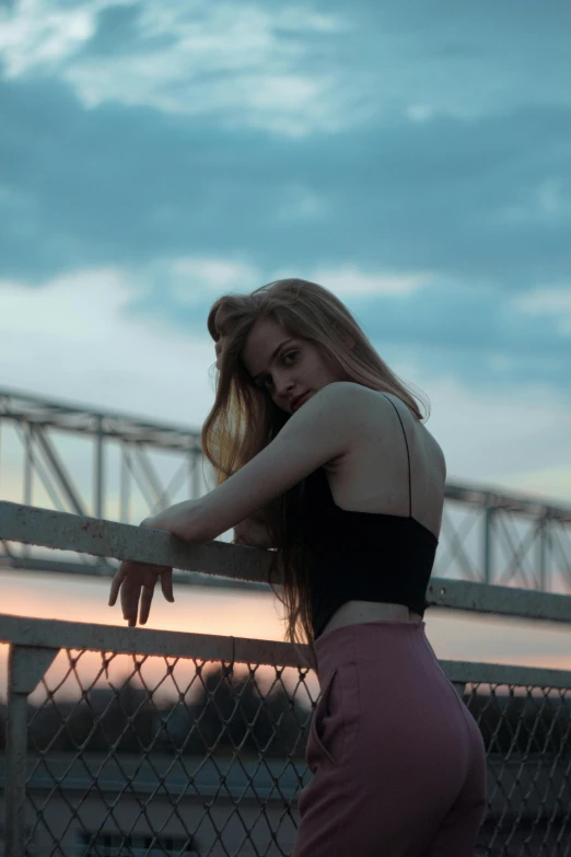 the girl is posing on the railing outside