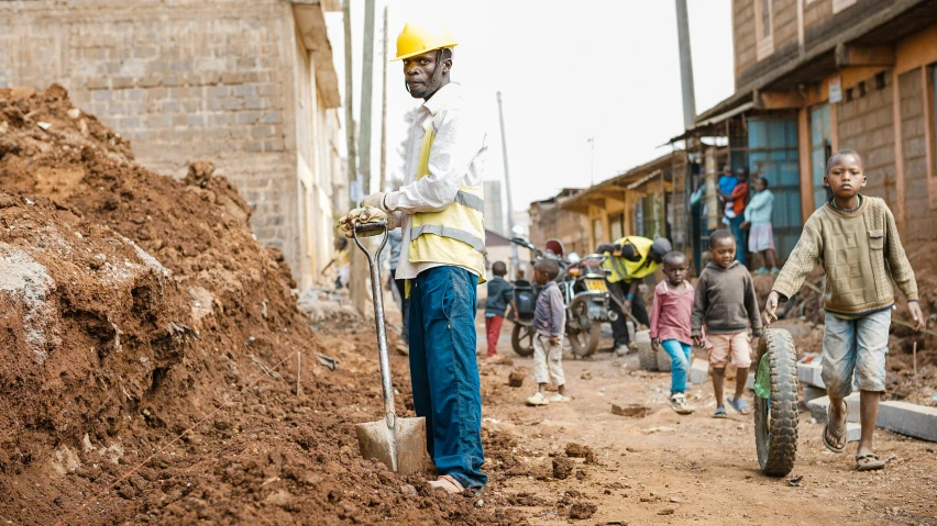 a man is standing in front of some dirt and holding a shovel