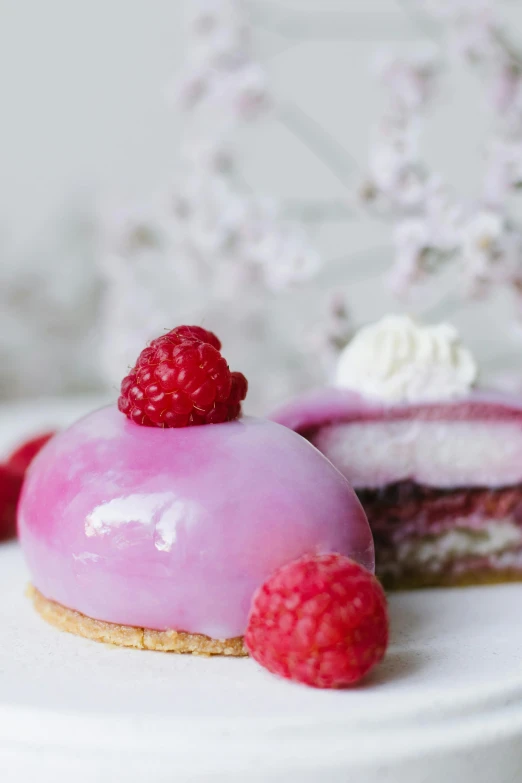 closeup of pastry with raspberries on white surface