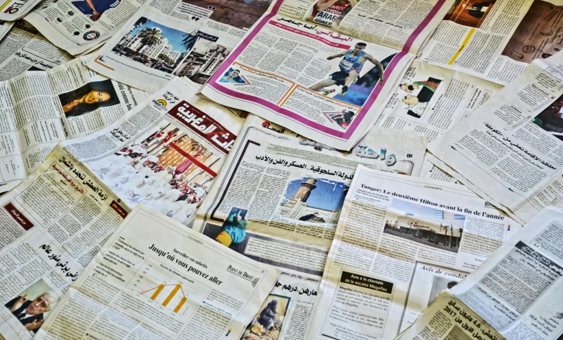 the many newspaper clippings have been stacked on top of each other