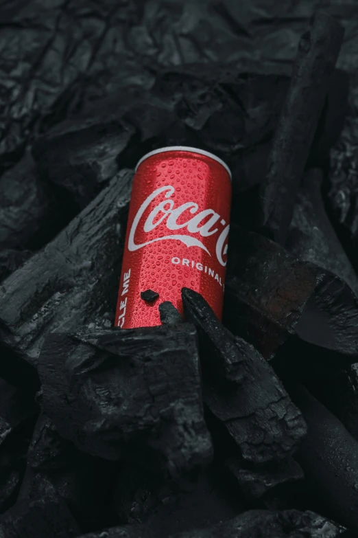 a can of coke sitting on top of black wood