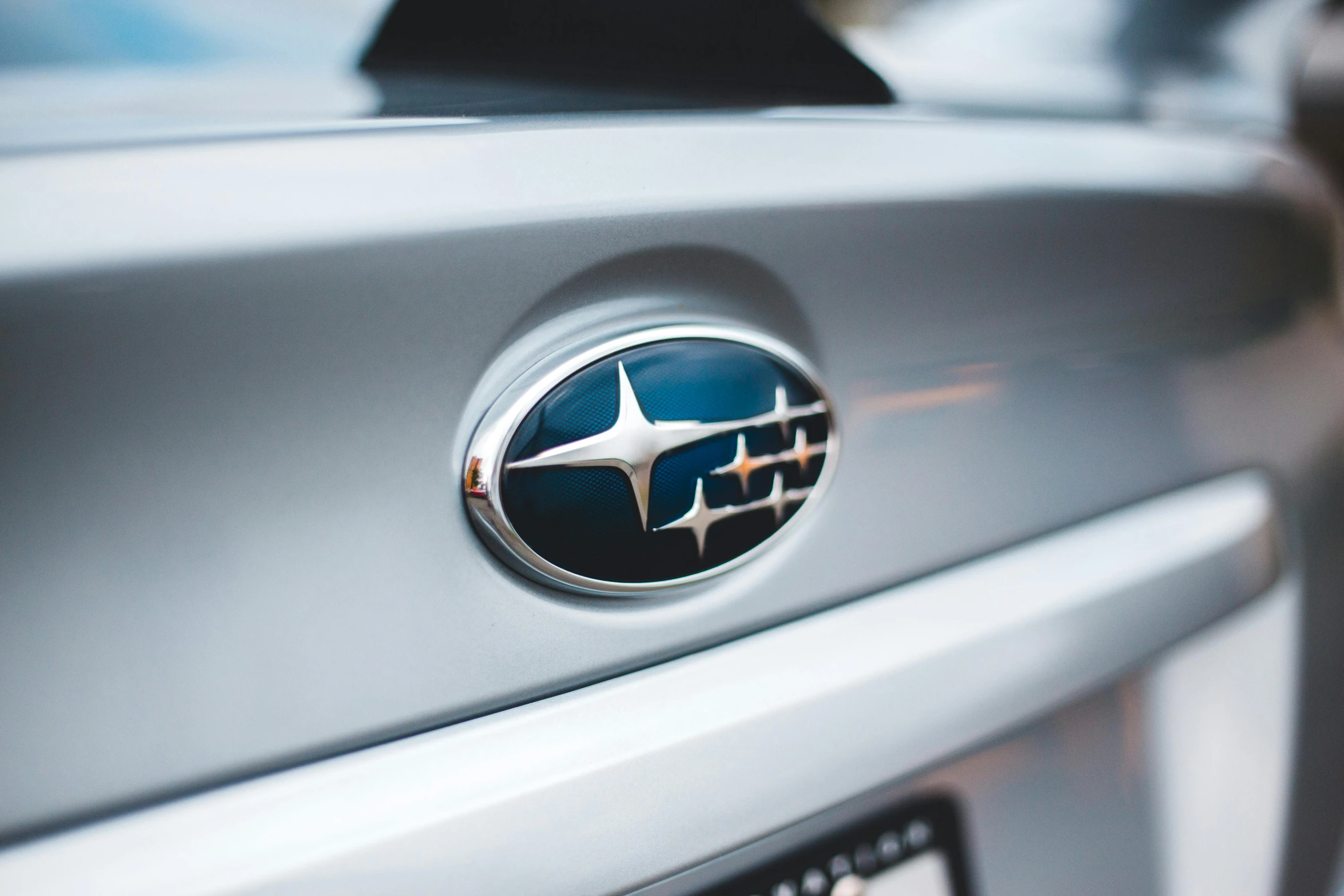 a close up of the badge on a silver and black car