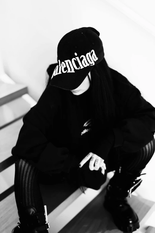 a girl sitting down on a bench wearing a hat with the word stickers on it