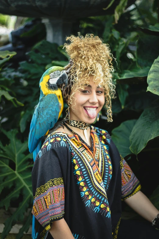 smiling woman with a parrot on her head