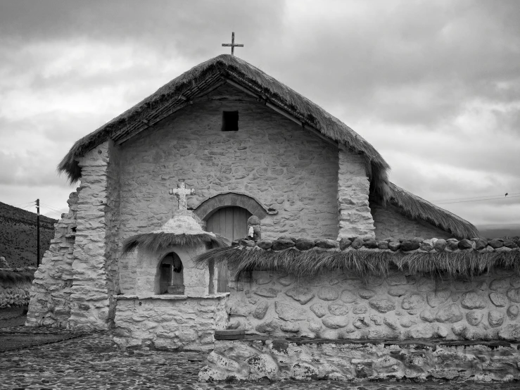 an old church with a tall grass roof