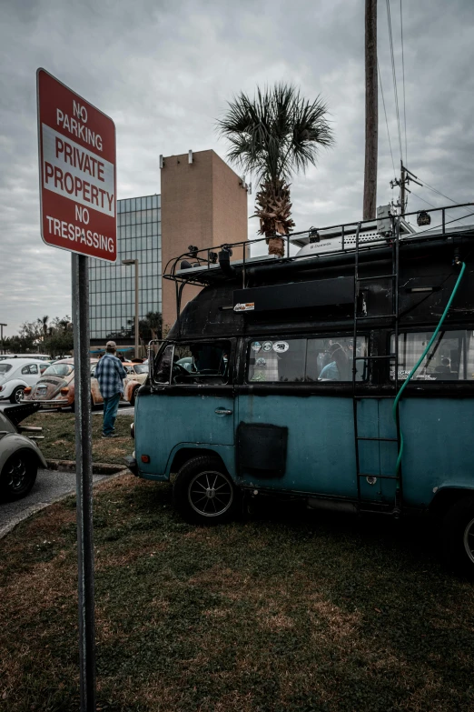 an old van parked outside with a street sign behind it