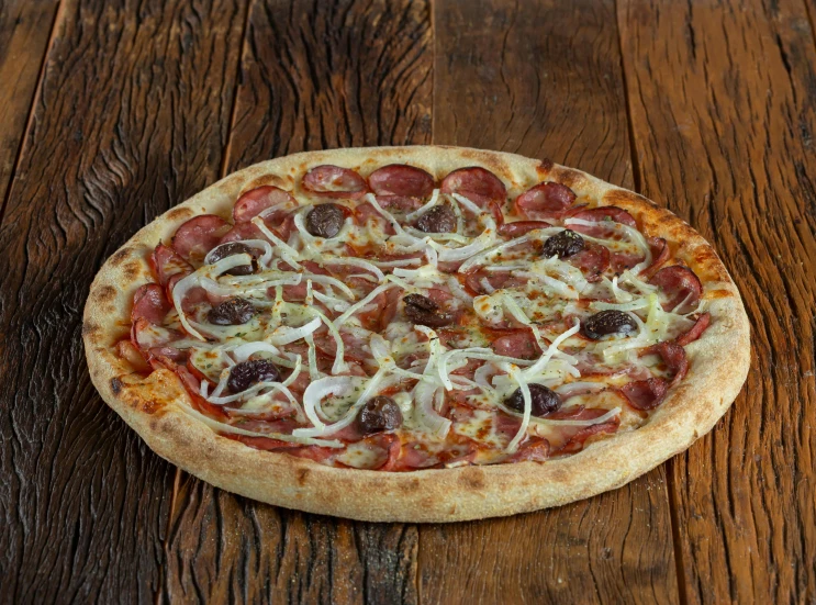 a small pizza with different toppings sitting on top of a wooden table