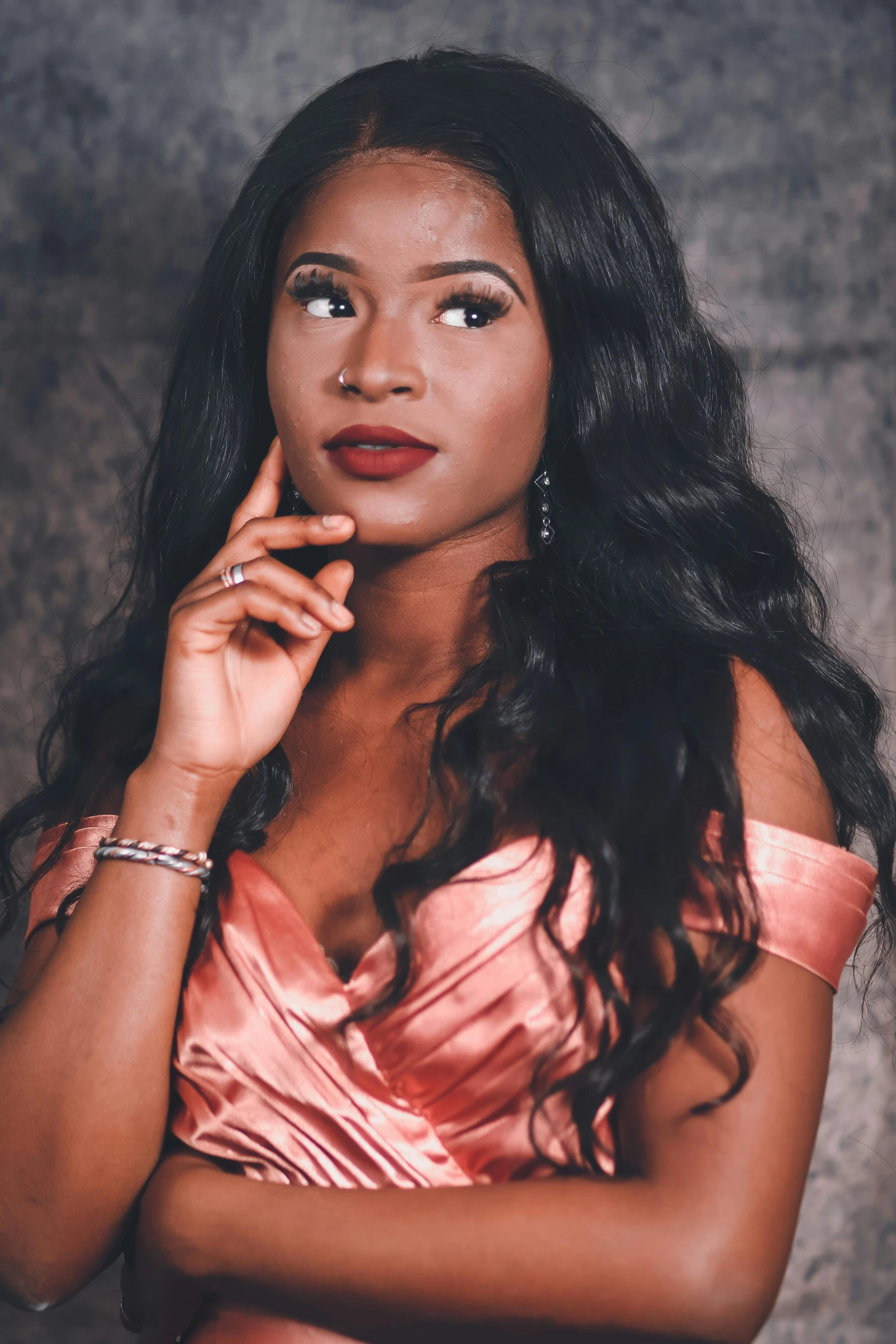 a beautiful woman wearing an orange dress holding a finger