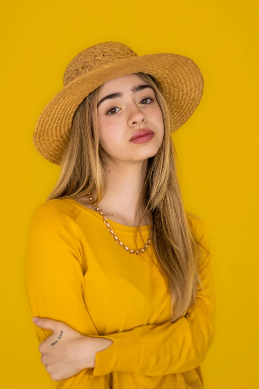 a woman wearing a yellow top and hat