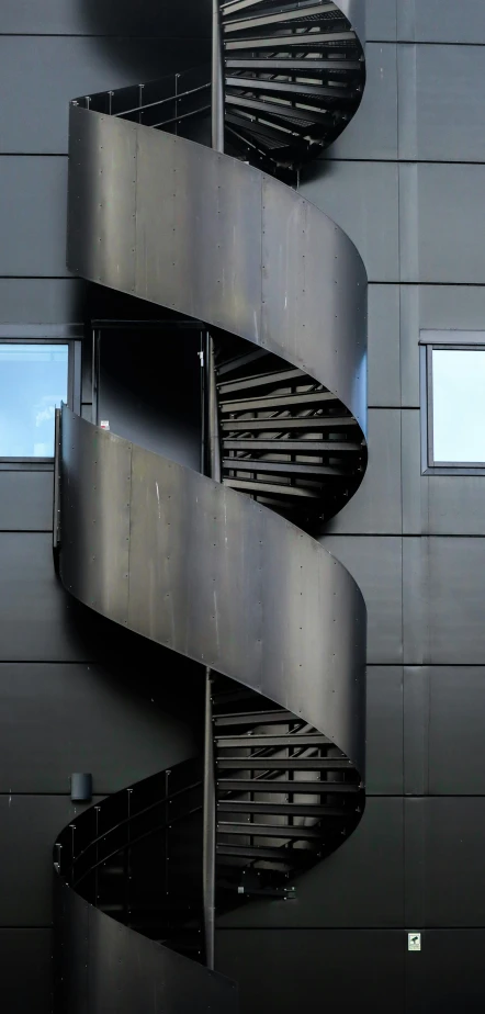 an abstract sculpture of curved metal pieces near the entrance of a building