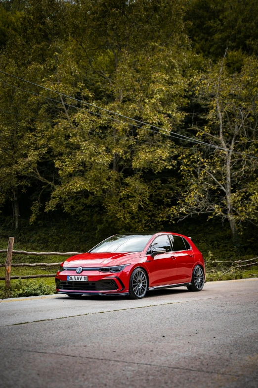 a red car is parked near some bushes