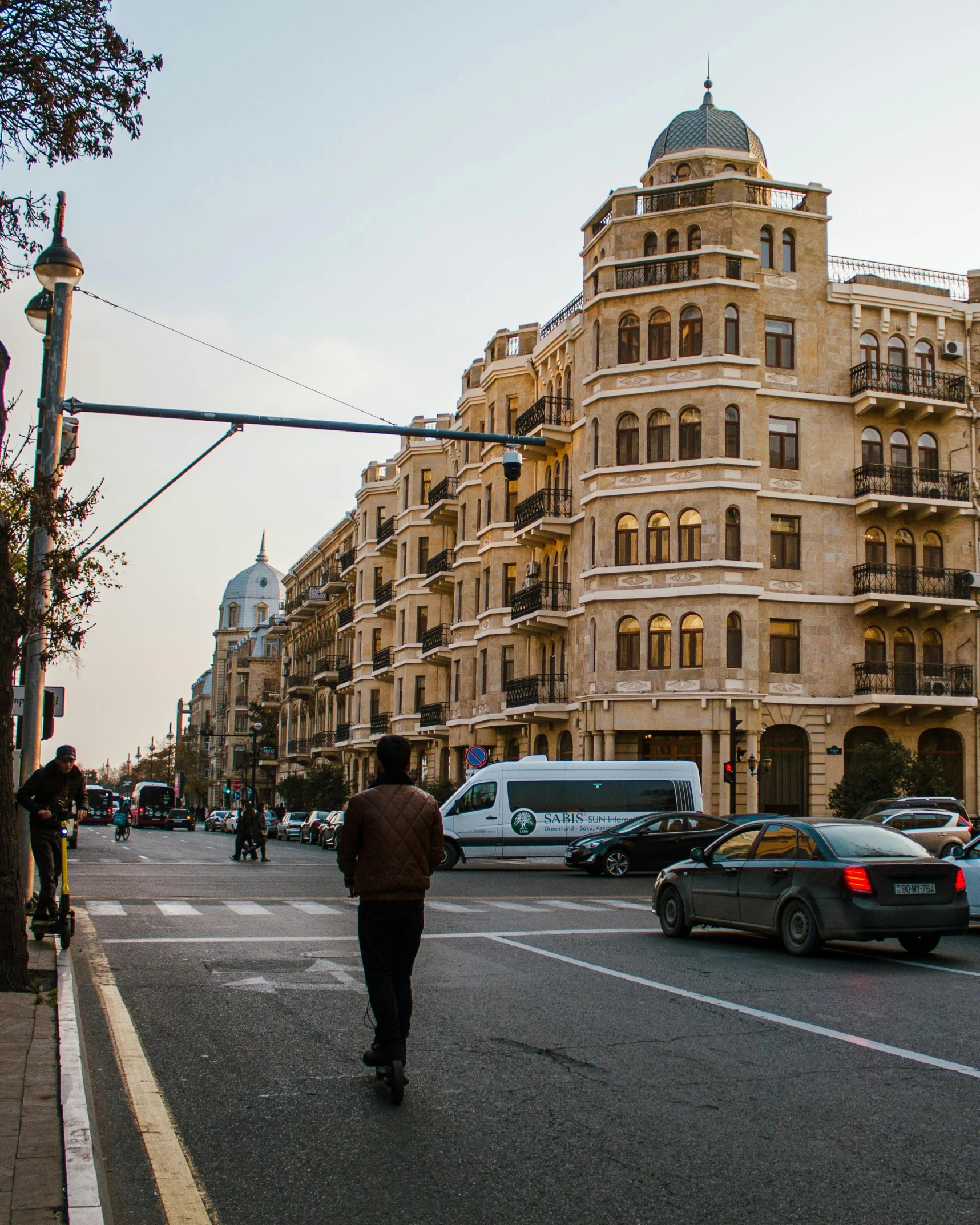 a man is walking across the street near cars