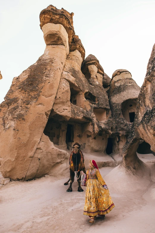 a man and a woman are standing near some rocks