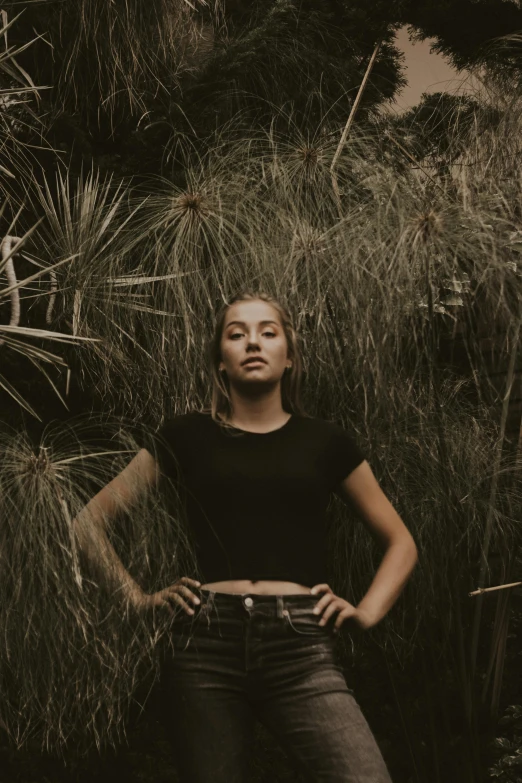 a woman poses near some tall grasses