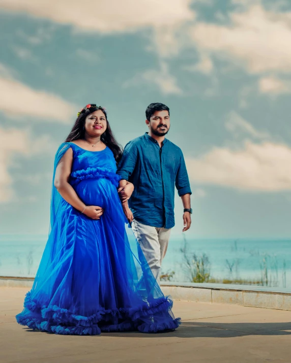 a man and woman are standing in front of the ocean