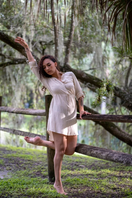 a woman posing in front of a wooden fence