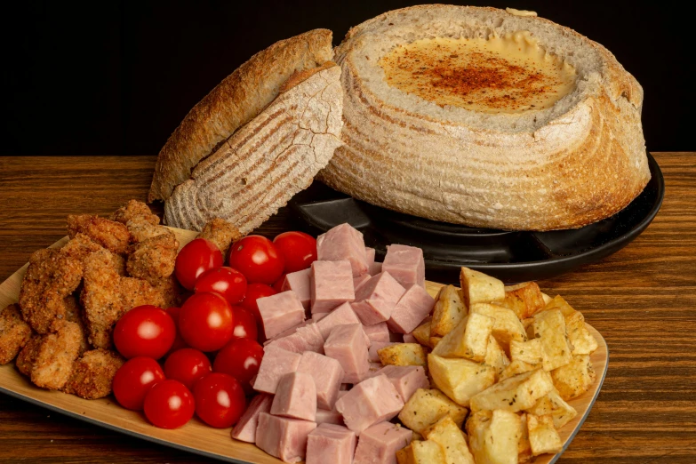a plate with ham, vegetables and bread