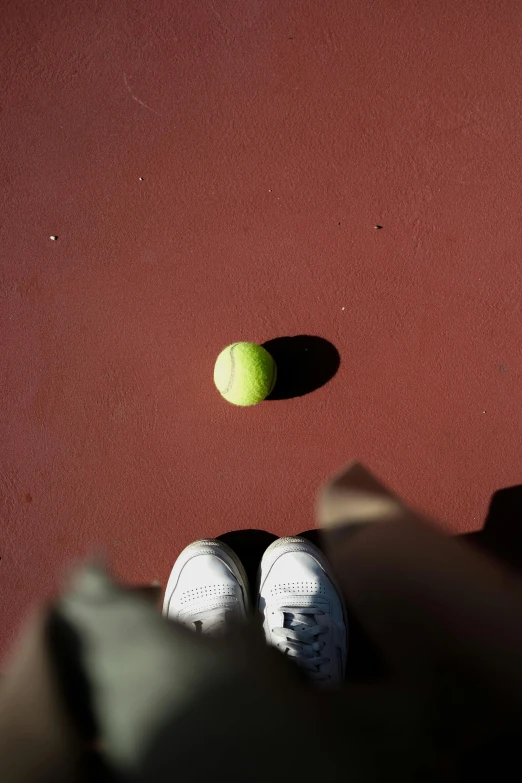 a tennis ball sitting on top of a tennis court