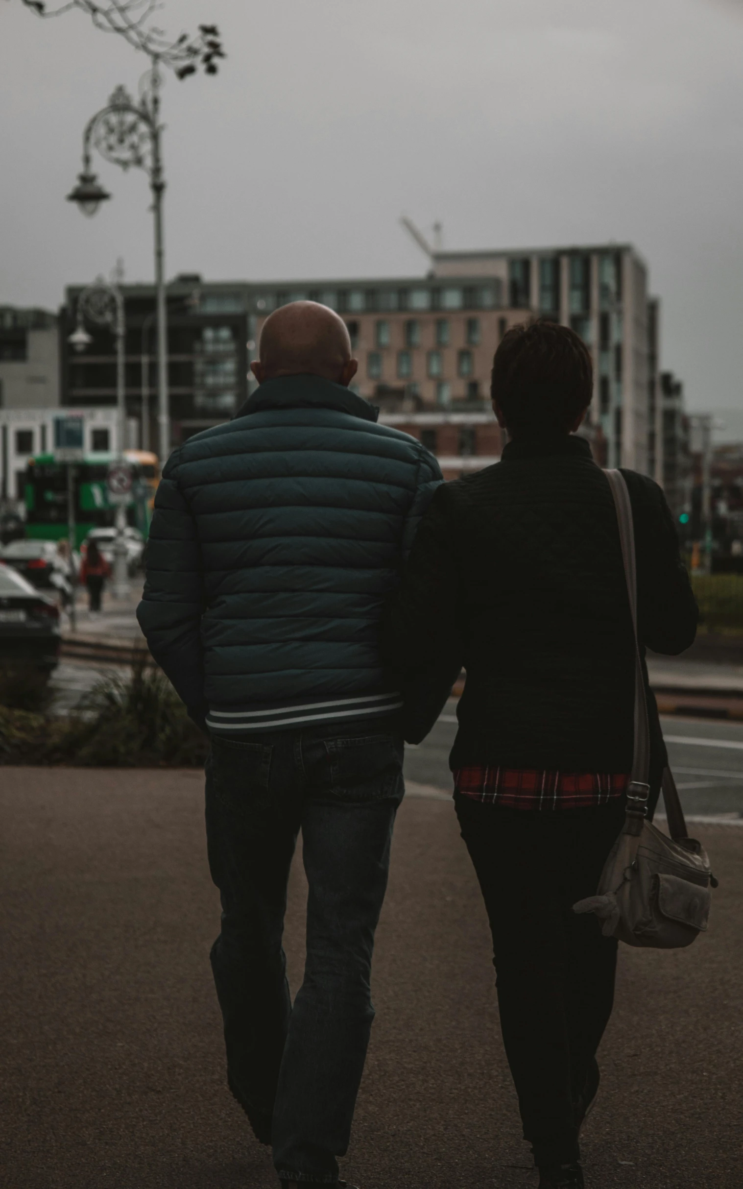 two people are walking together down the street