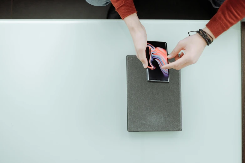 a person holding an object on the table top