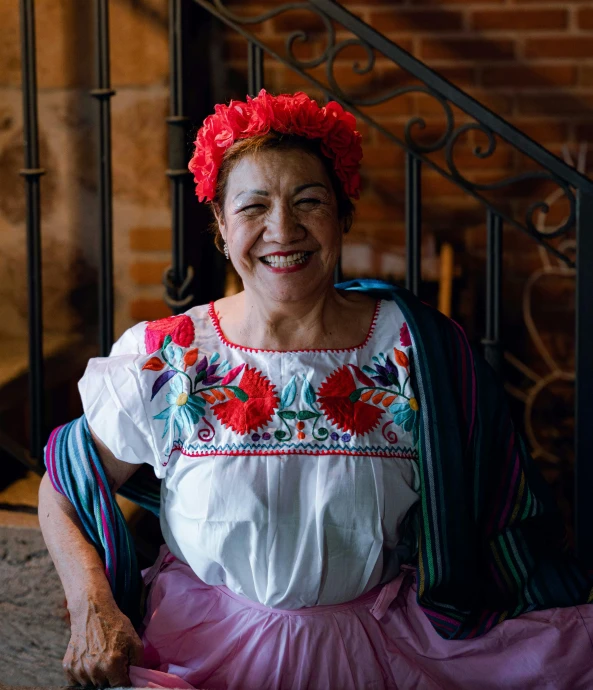 a woman in traditional mexican dress posing for the camera