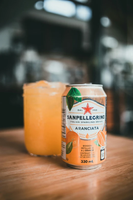 an orange beverage sitting on top of a wooden table