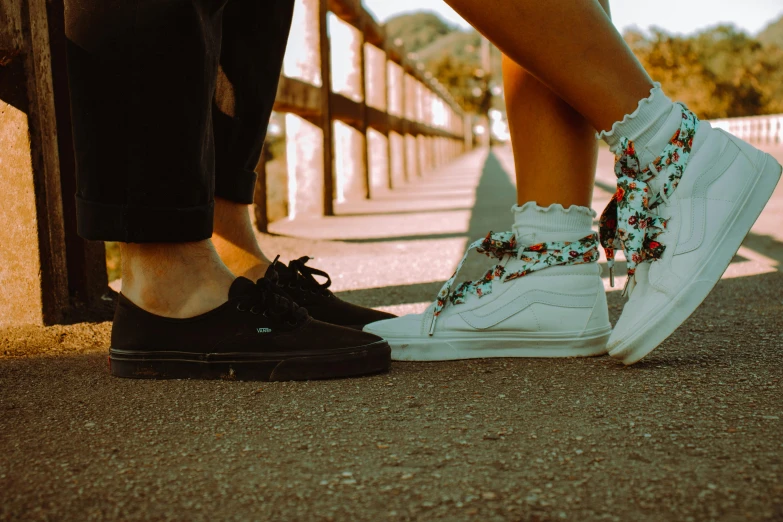 two people standing next to each other in white shoes