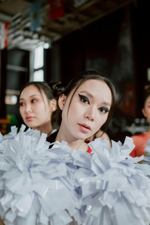 several people wearing white outfits and one is holding onto a pair of tissue paper