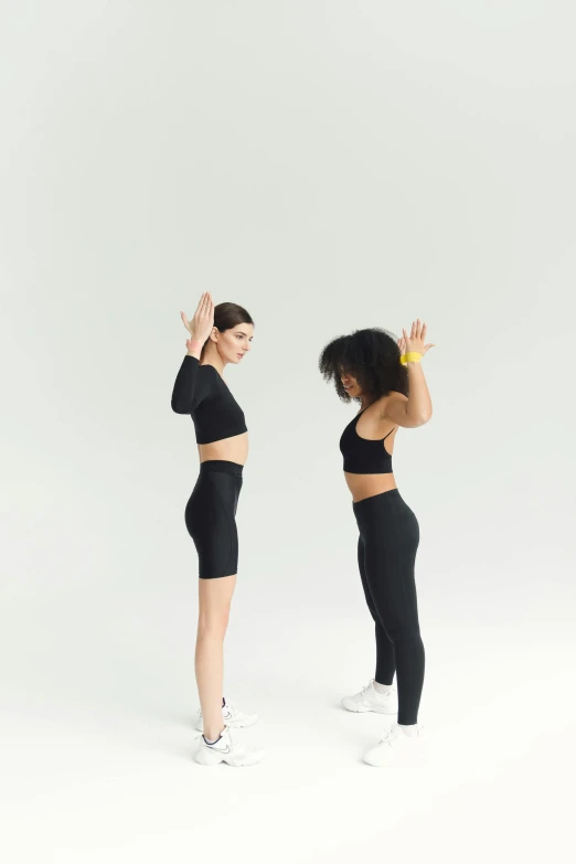 two women in black outfits posing for the camera