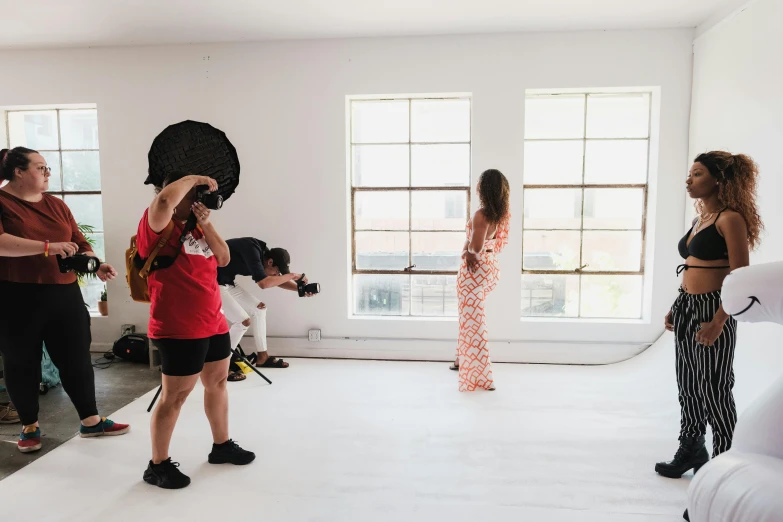 two girls with cameras in front of some other people