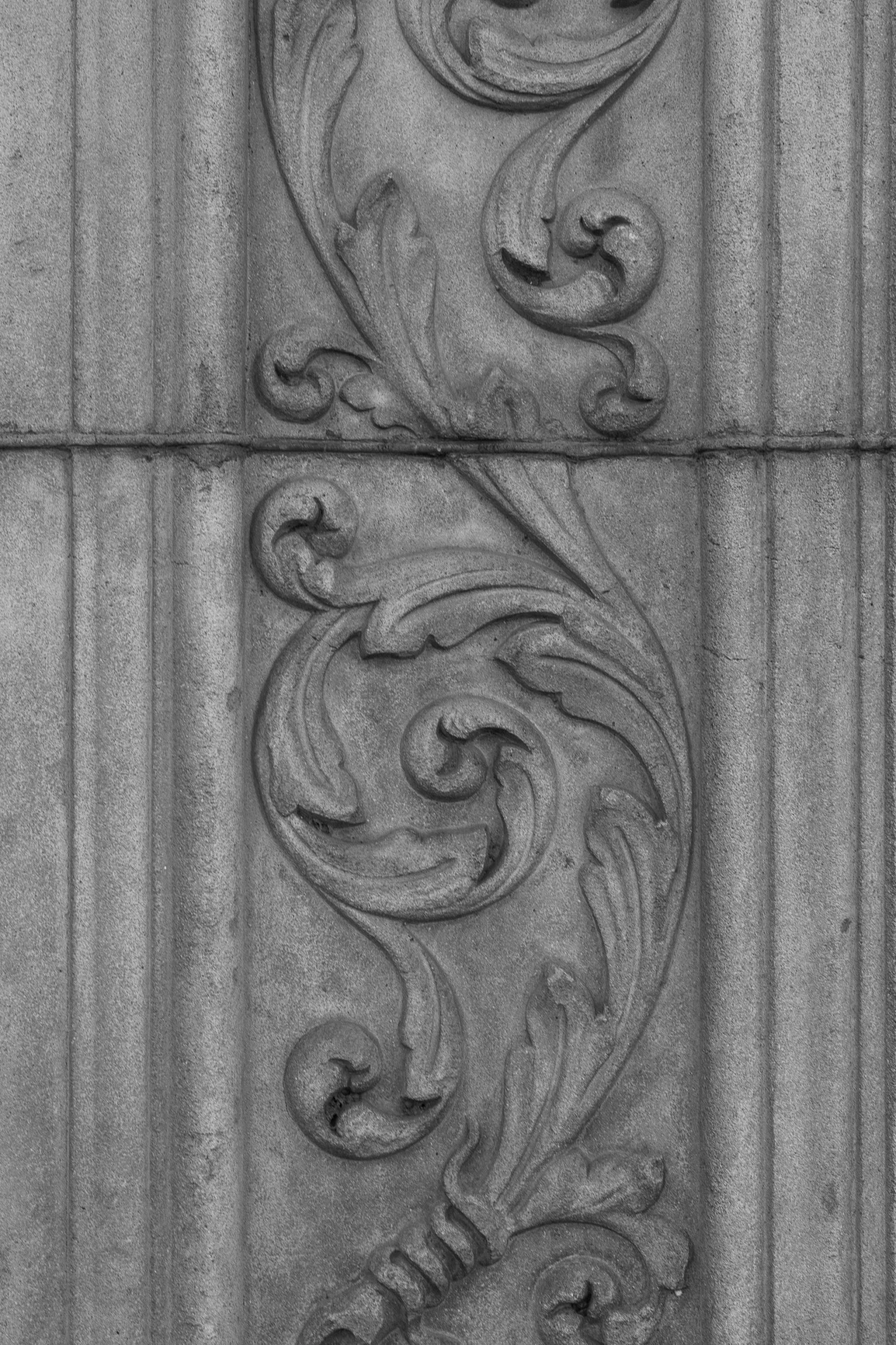 two carvings on the side of a building with many small holes