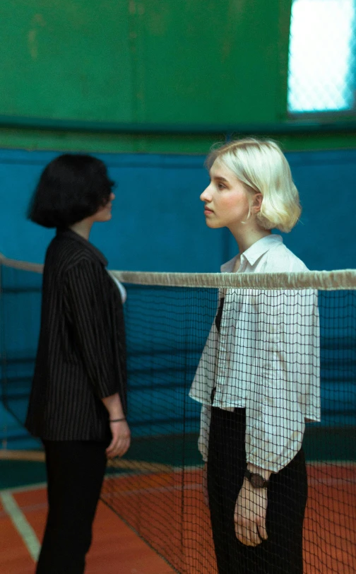 a man standing in front of a woman holding a tennis racket