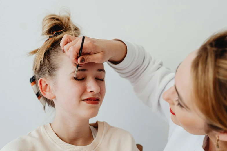 woman looking into mirror while doing hair care