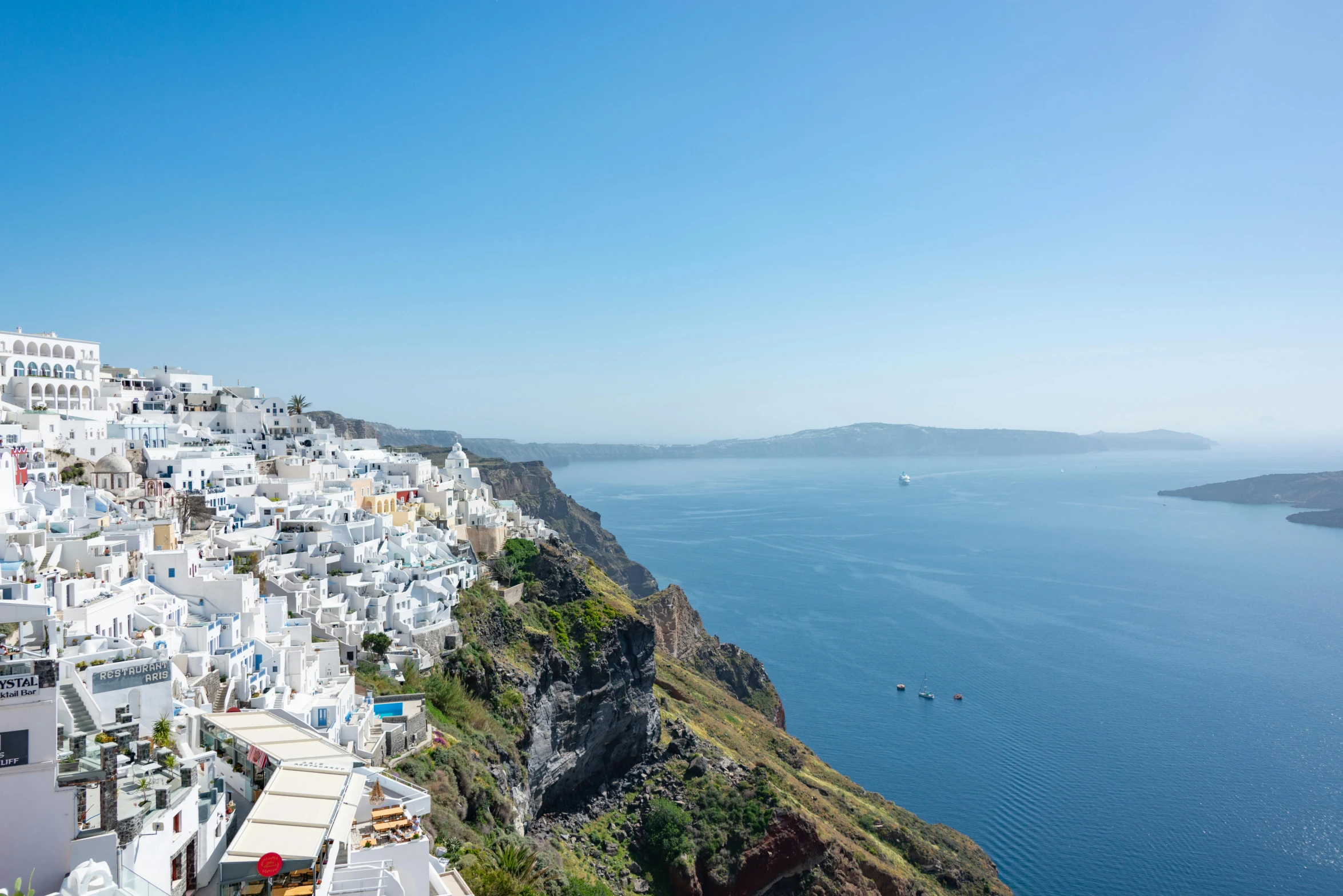 a blue water bay and some buildings on a hill