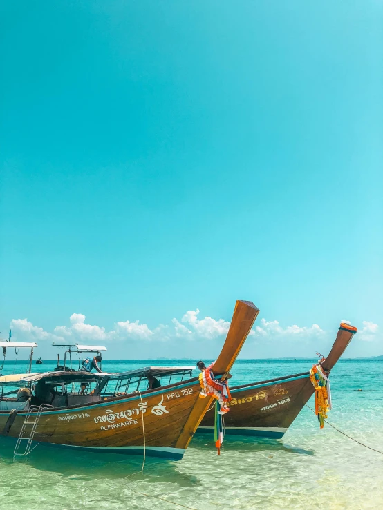 several canoes on the ocean with one holding out its sail