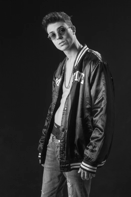 a young man poses in a bomber jacket